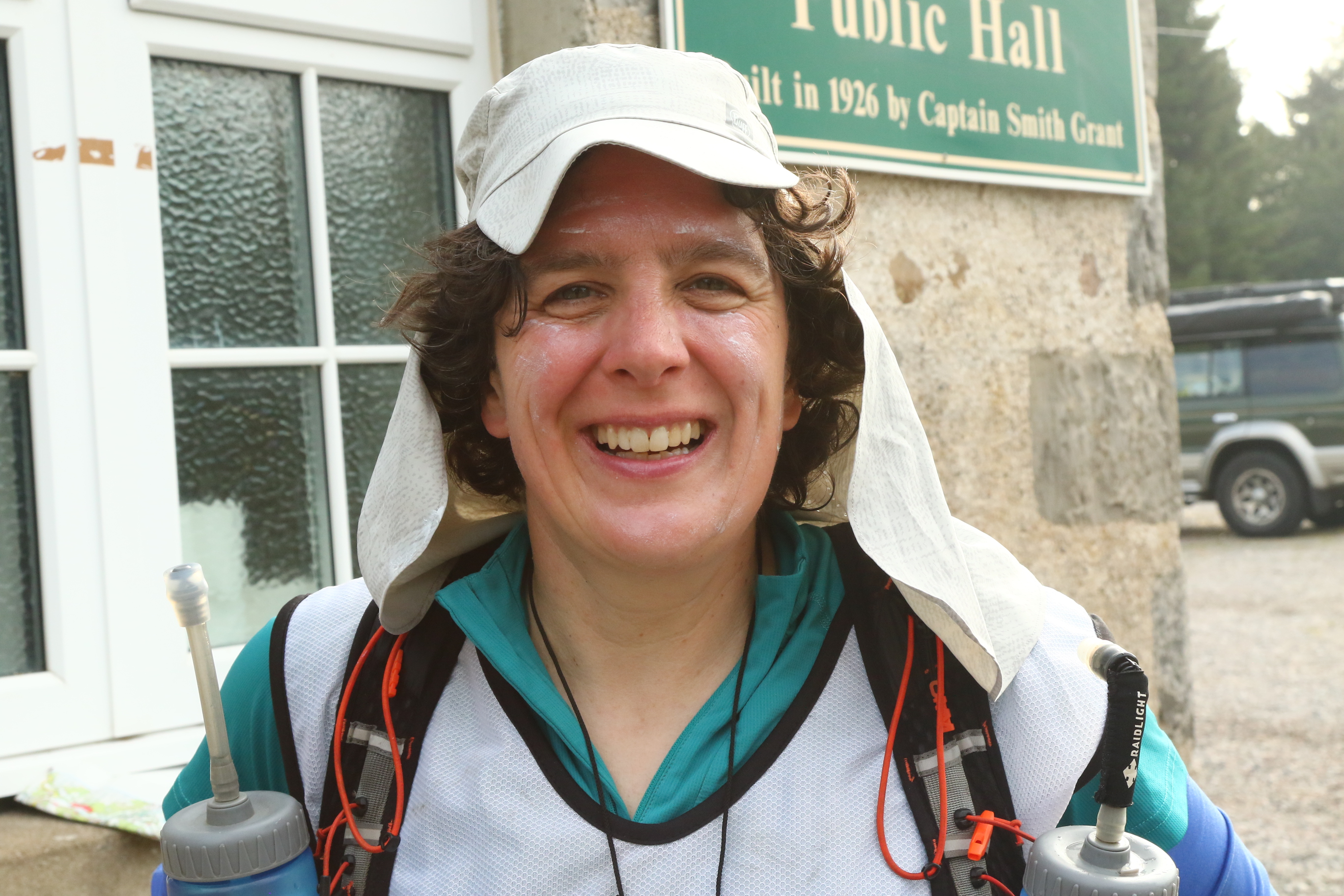 Me smiling at transition, wearing a 'sahara cap' and with white sun cream smeared all over my face